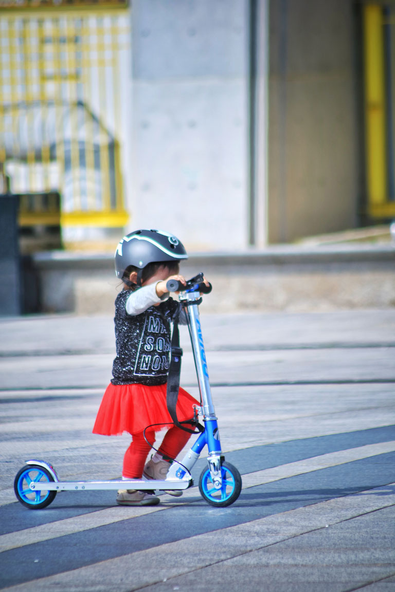 toddler-using-scooter-on-road-Skuter