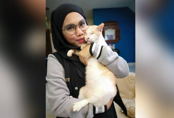Siti Khadijah bersama salah seekor kucing yang diselamatkannya