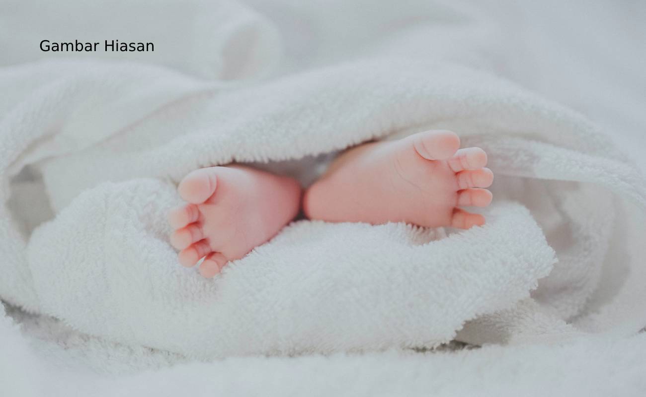 barefooted baby covering white blanket