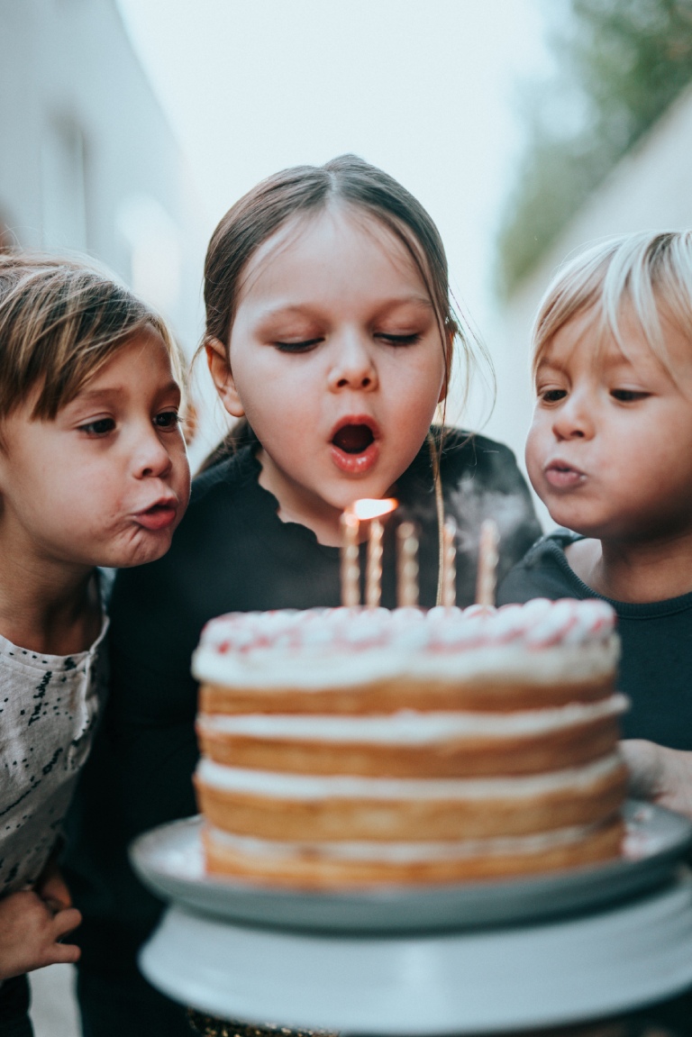 girl blowing candle on cake